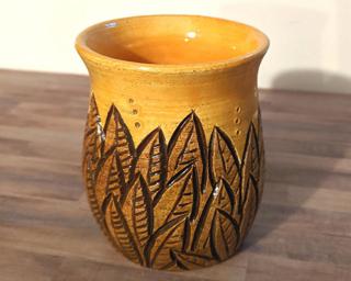 Adorn your home with this one of a kind vase which sports multiple carved leaves around an glossy gold vessel.