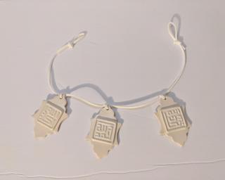 Adorn your home with this string of three white ceramic lanterns, each depicting a phrase in Arabic written in the Kufic style.