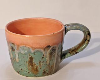 A lovely ceramic mug with unique blend of drippy glazes around the outside.