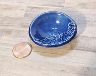 A sweet little blue dish with a lace pattern, perfect for holding rings, or a great addition to one's doll house accessories' collection.