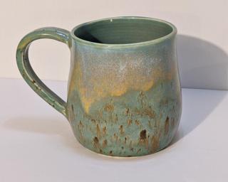 A lovely ceramic mug with unique blend of drippy glazes around the outside.