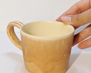 A soft pink ceramic mug, perfect for a morning cup of coffee.