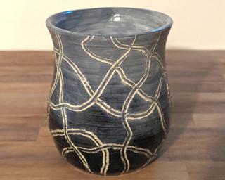 Adorn your home with this one of a kind vase which sports multiple carved squiggles around an ombre shaded vessel.