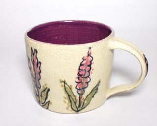 A lovely ceramic mug with lavender flowers painted around the outside.