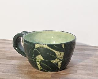 A carefully carved ceramic mug, perfect for a morning latte.