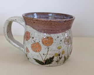 A carefully painted and carved ceramic mug, perfect for your morning cup of tea or coffee.