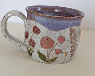 A carefully painted and carved ceramic mug, perfect for your morning cup of tea or coffee.